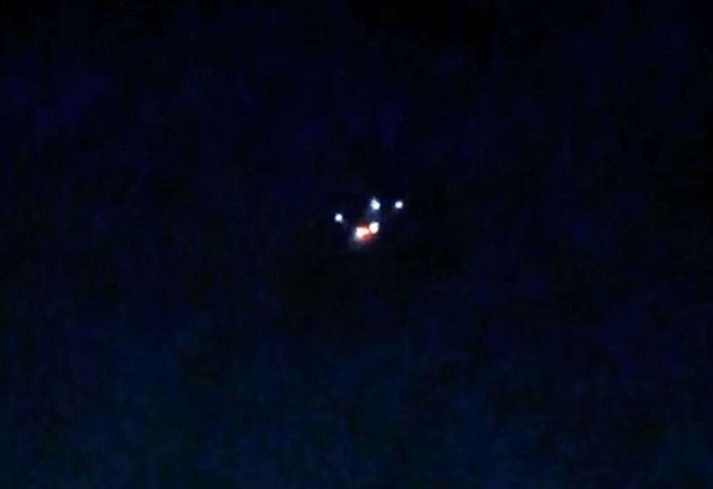 A blurry photo of what appears to be a drone in the night sky